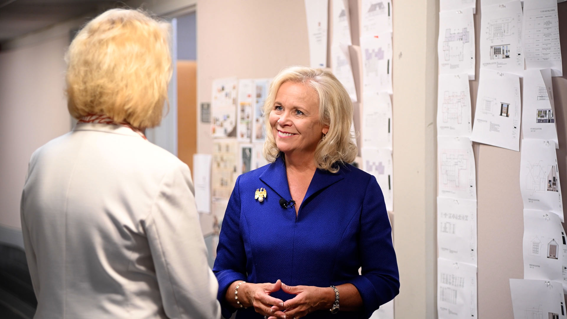 two women talking in a hallway