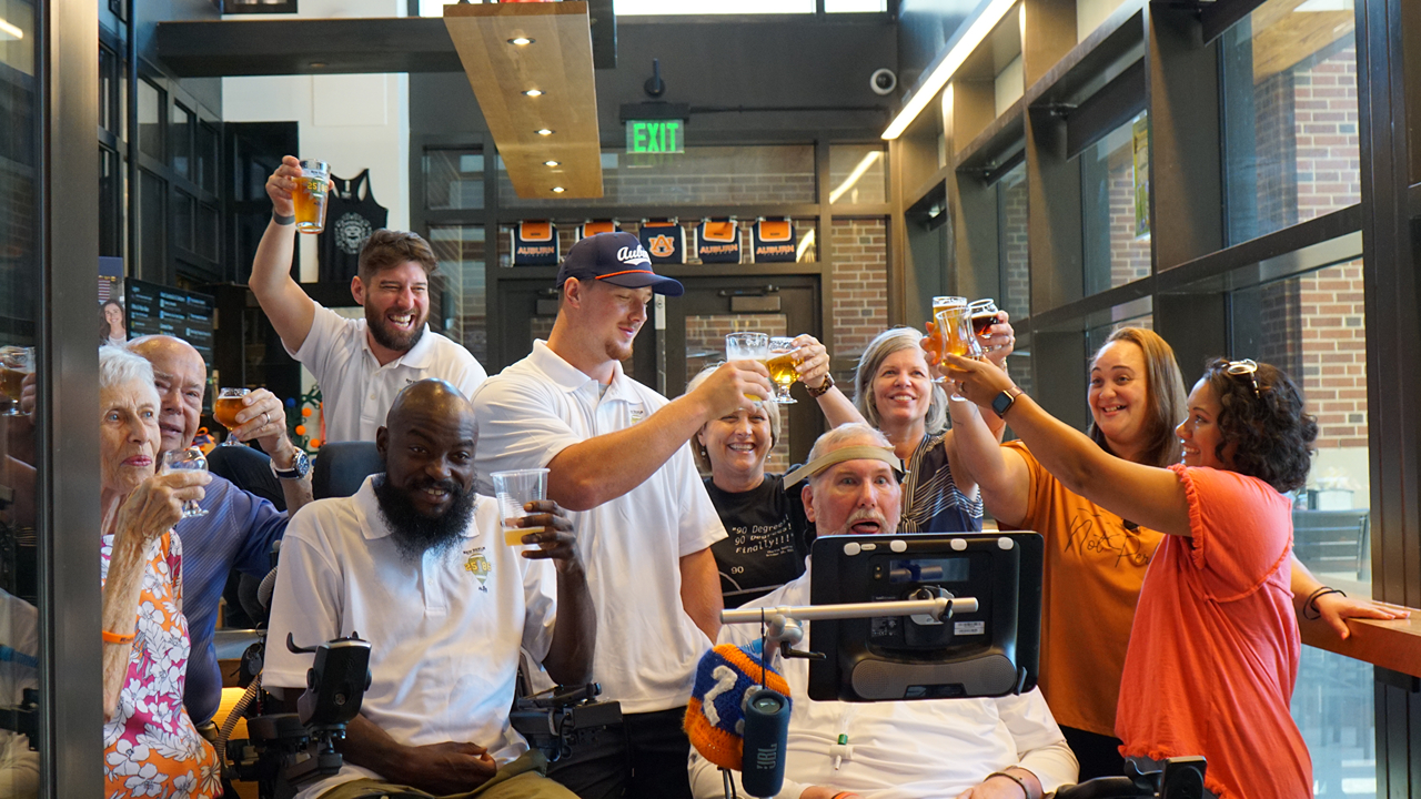 A group raises their pints of 2586 beer.