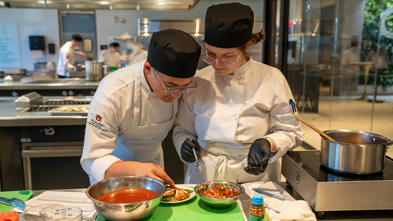 Hospitality students work on preparing an oyster dish