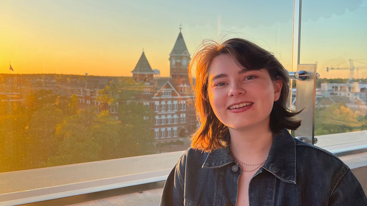 Emily Findlay with a sunset background featuring Samford Hall.