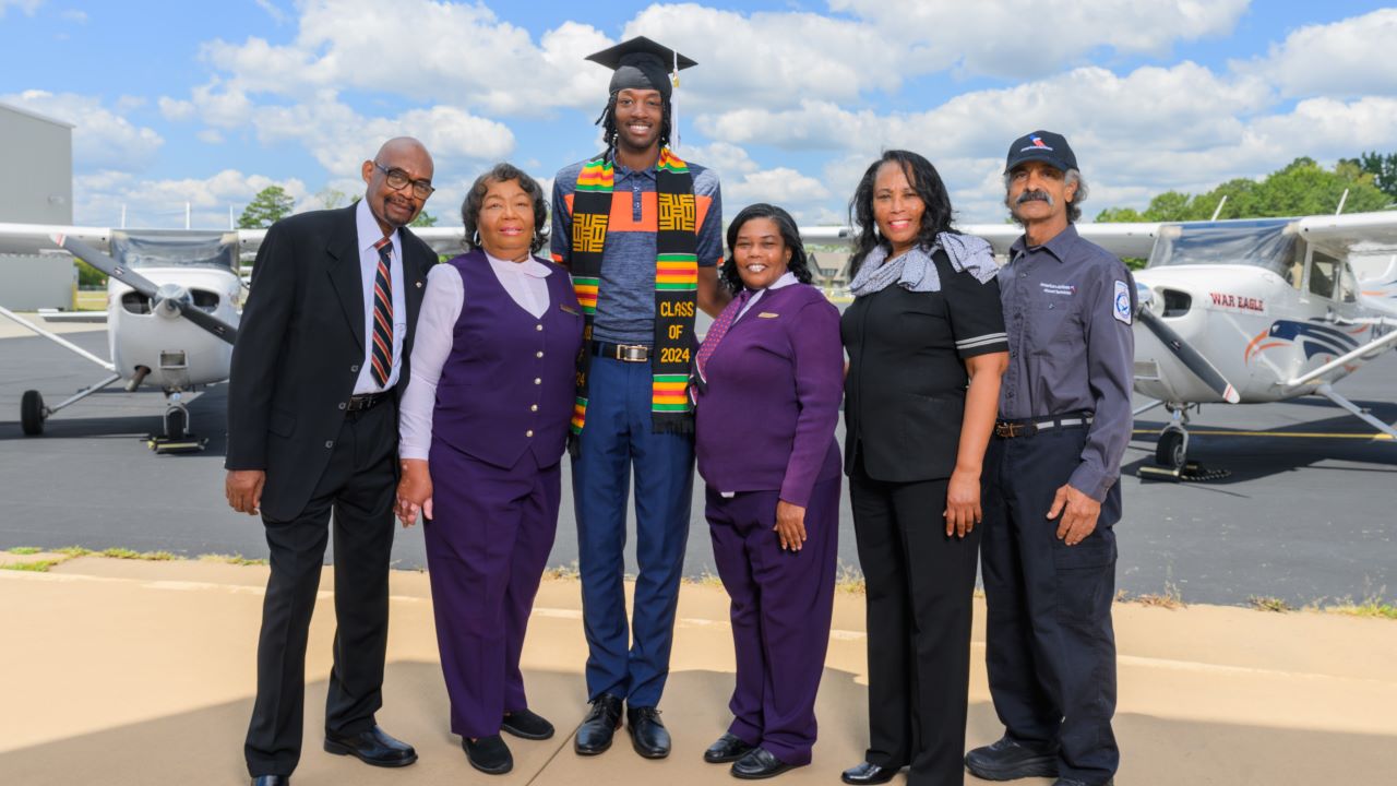 Sims family posing for photo at the Auburn airport