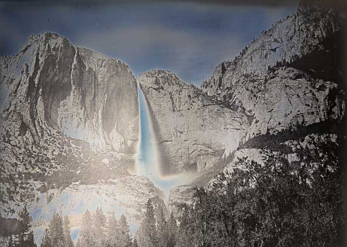 A waterfall pours over a rock formation in Yosemite National Park