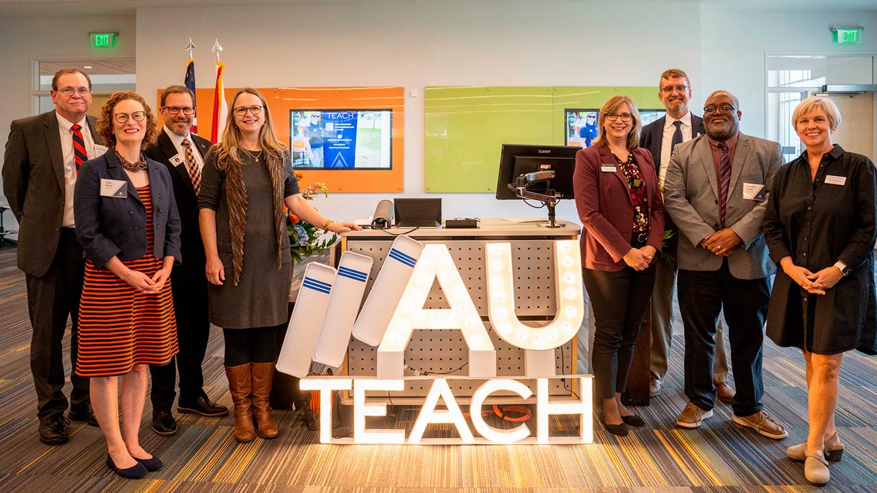 A group of people pose for a photo at the AUTeach kickoff event.