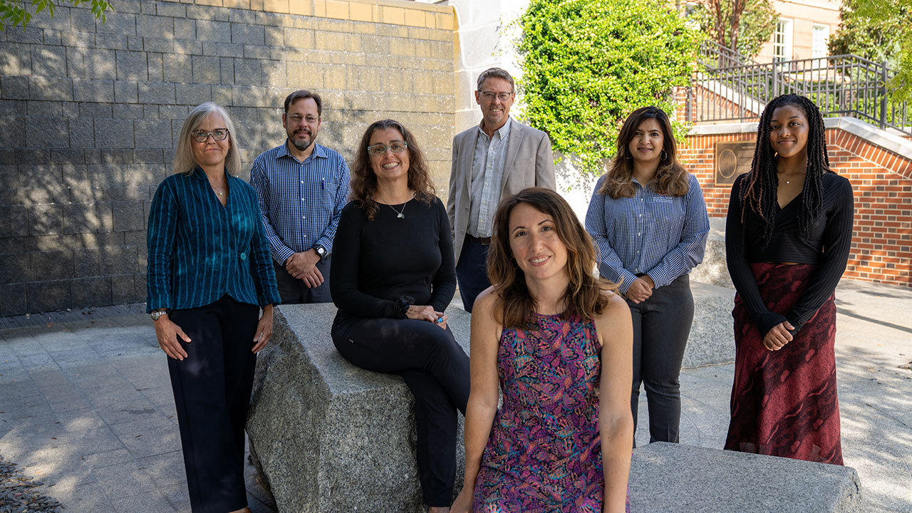 A group of seven interdisciplinary scholars poses for a photo