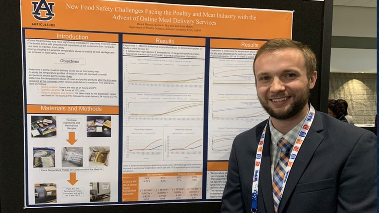 Brock Herron stands in front of his research poster.