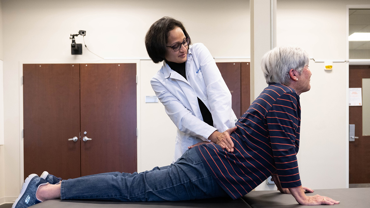 a physical therapist helps a woman stretch her core