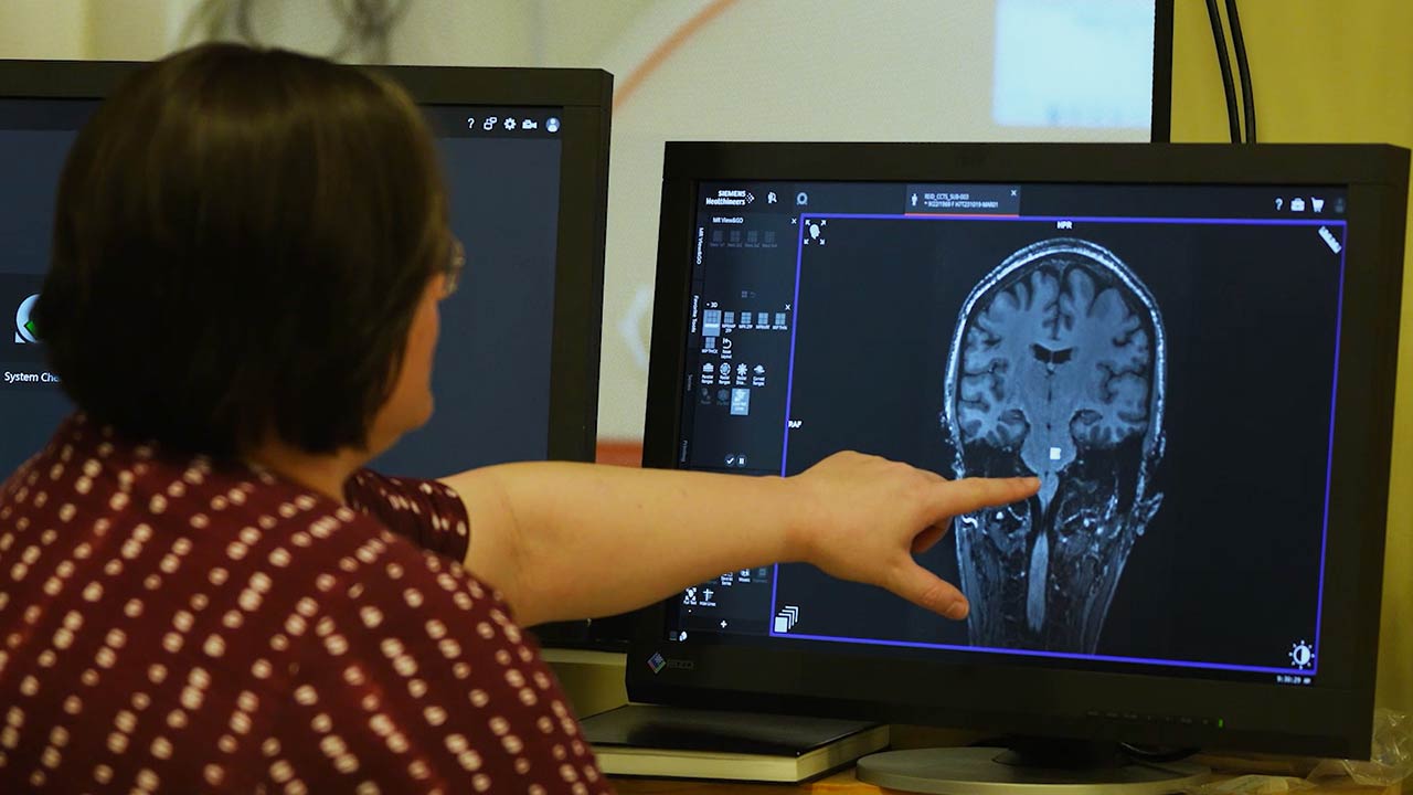 Woman points at MRI screen