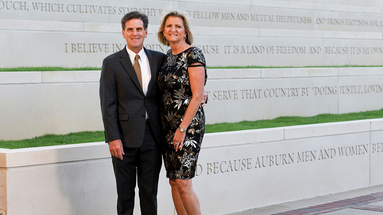 Rick and Carolyn Salanitri stand in front of building at Auburn University