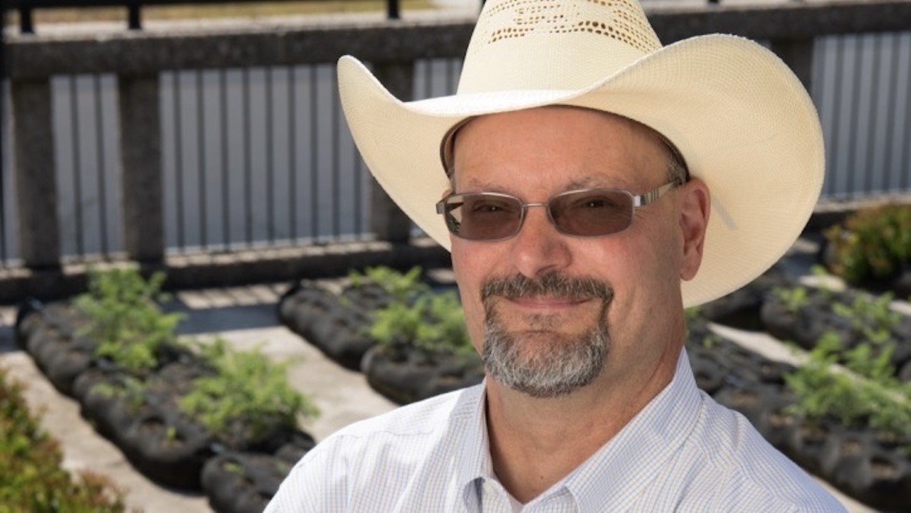 Photo of man outside in sunglasses and hat smiling