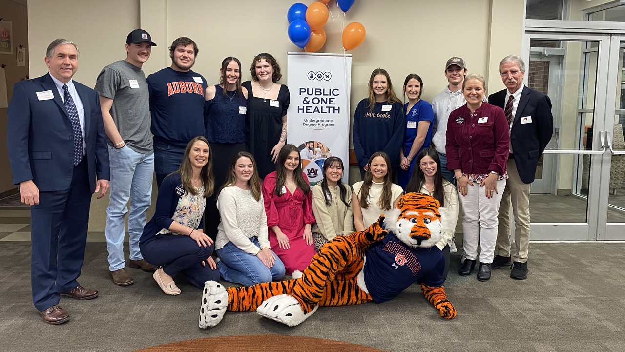 Group of professors, students, and tiger mascot smiling