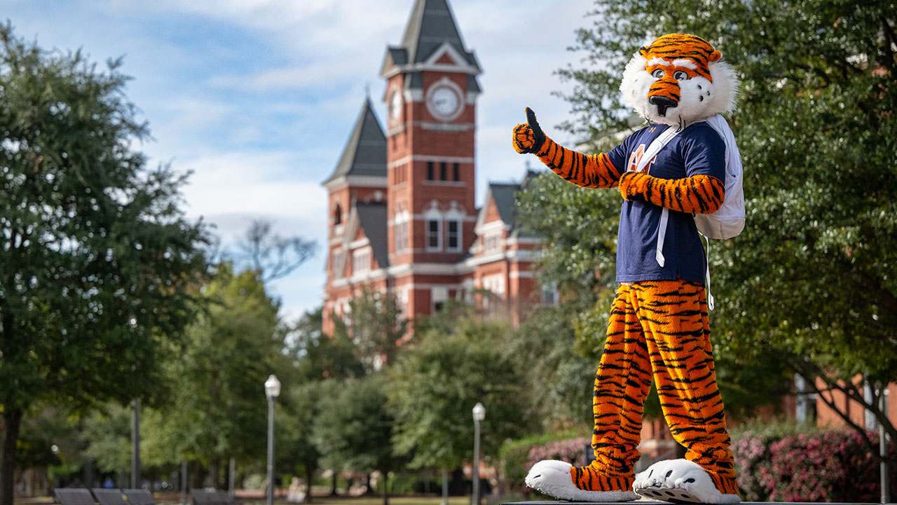 Auburn mascot Aubie gives a thumbs up in front of Samford Hall