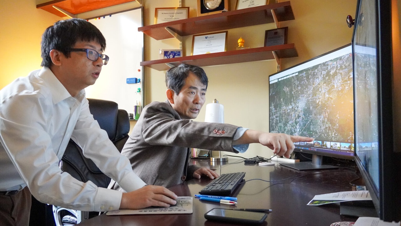 Two GSEI professors looking at computer screen 