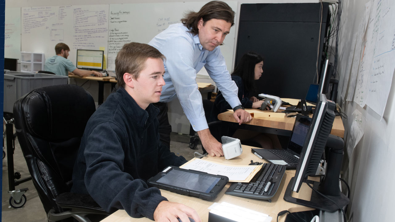 Justin Patton, director of the Auburn RFID Lab, works with a student in the lab.