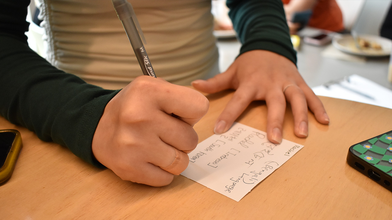 hands write on a note