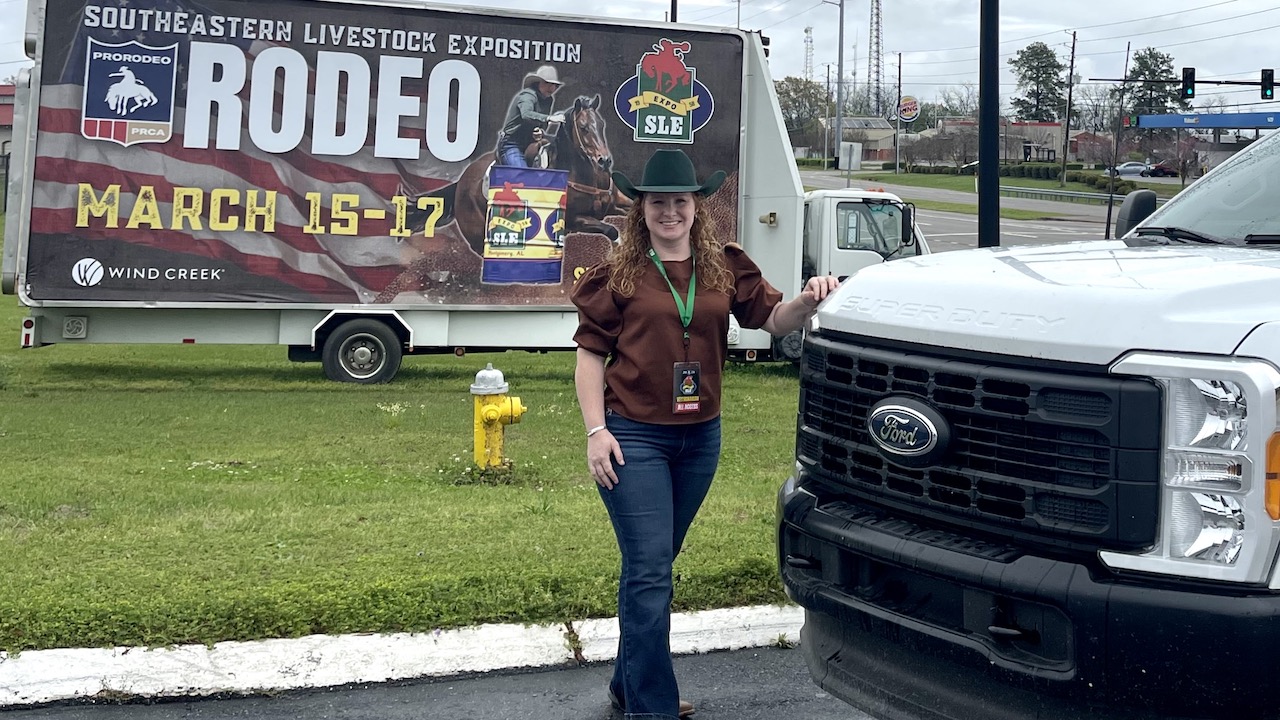 Photo of women in front of truck and rodeo sign