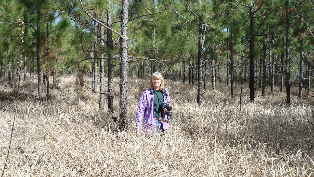 Women in field of grass with camera 