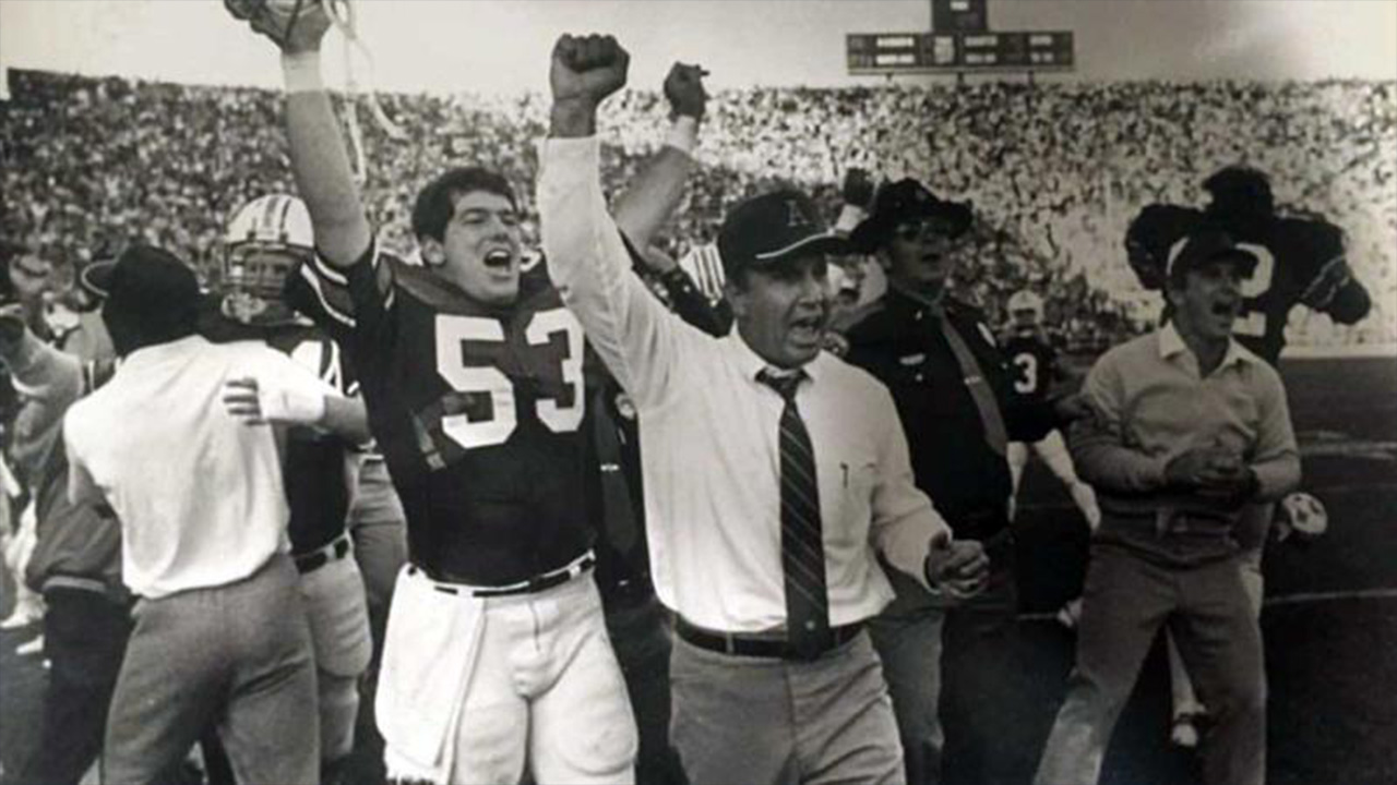 An old black and white photo shows football players celebrating after a win