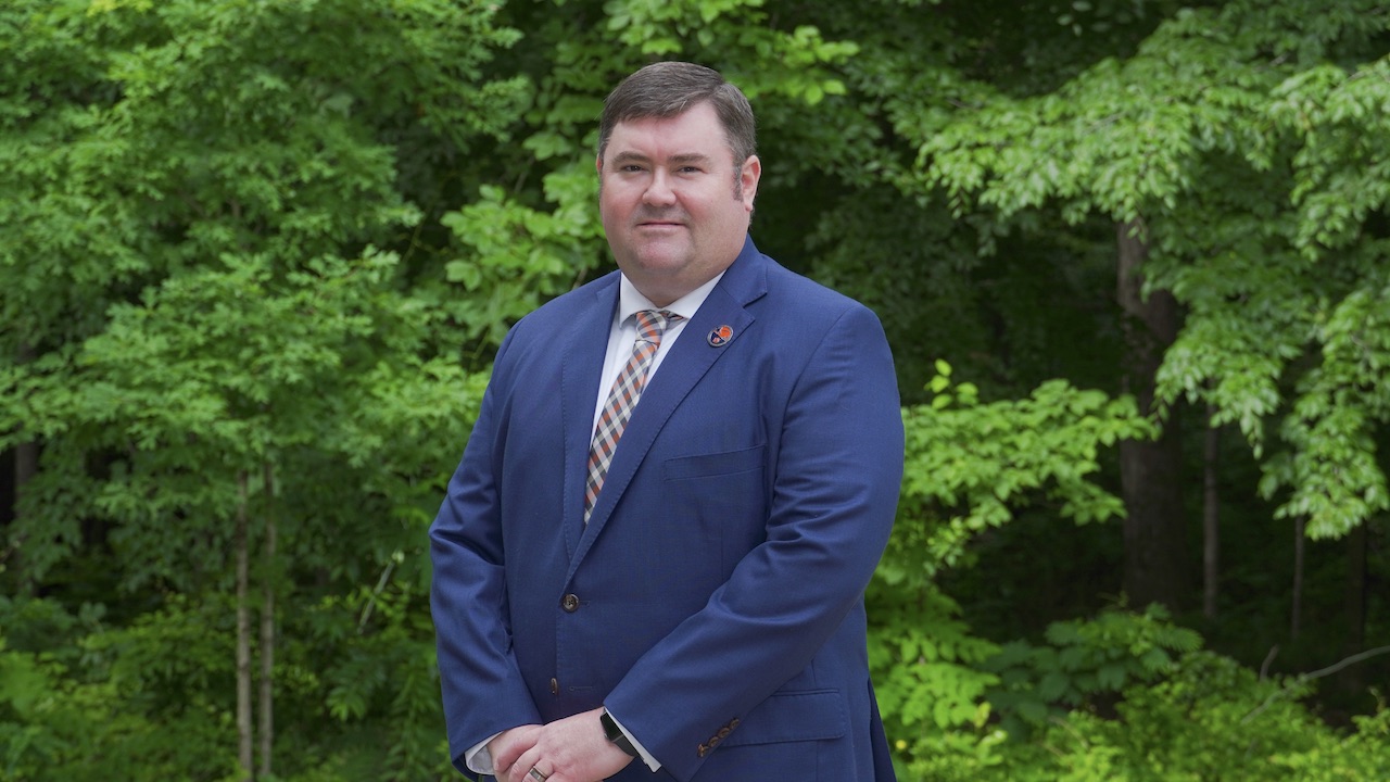 Man outside in suit smiling for camera