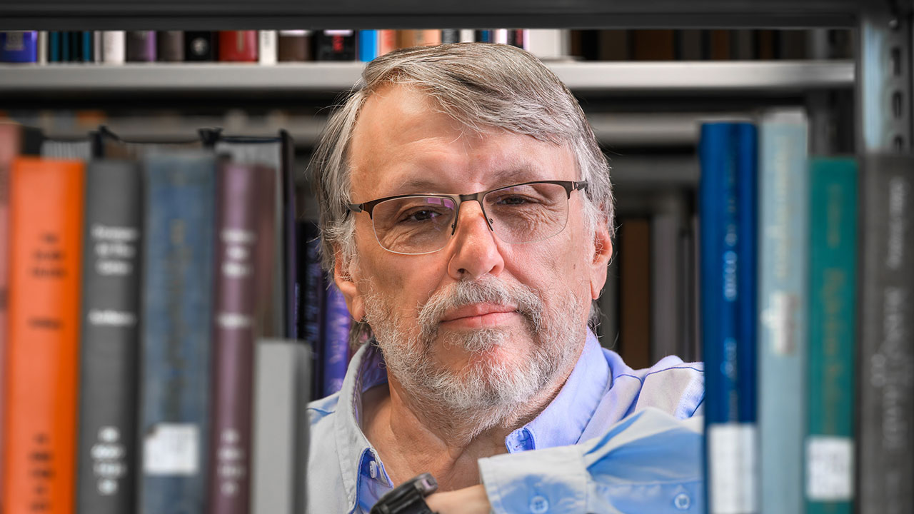 Jayson Hill peers through a row of library books