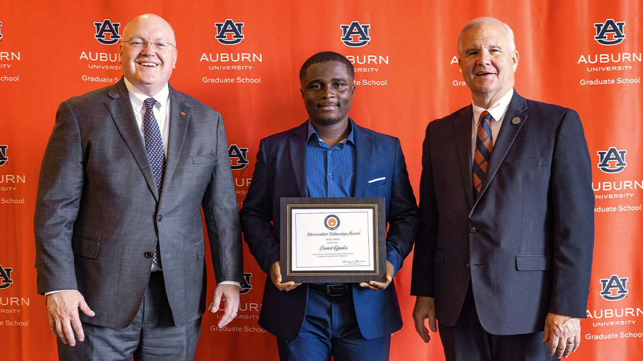 Three men with an award smile for the camera
