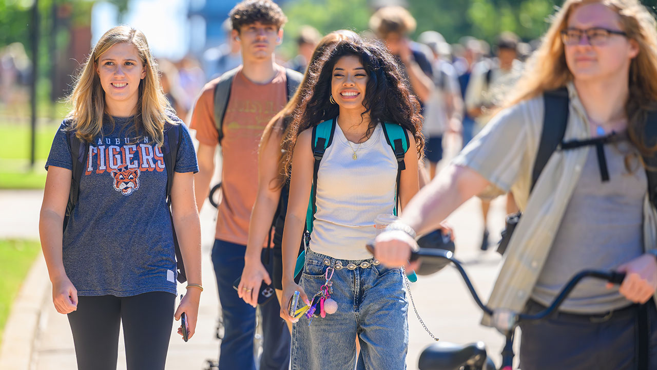 Students are walking and smiling on campus.