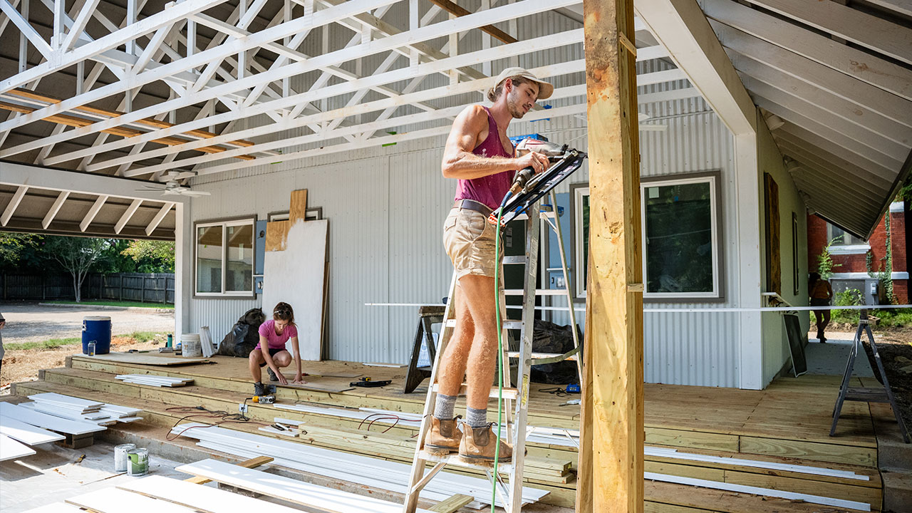 Two people building a building