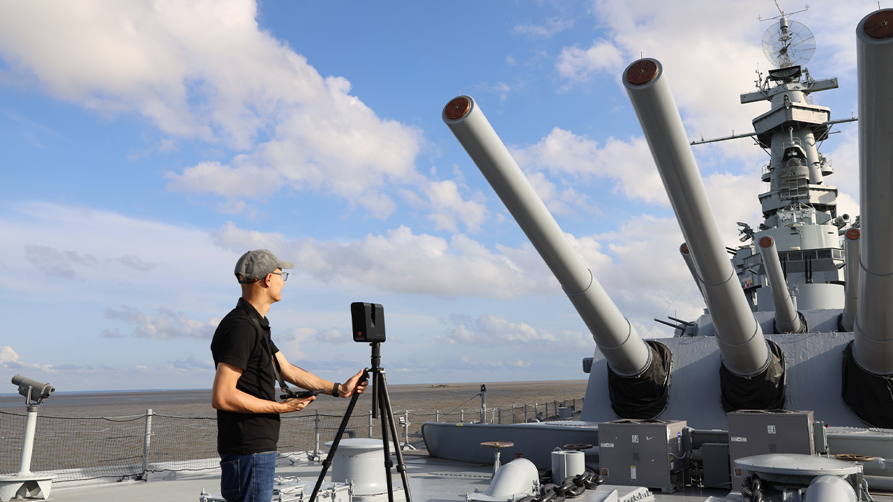 Junshan Liu checks his camera on the deck of the USS Alabama