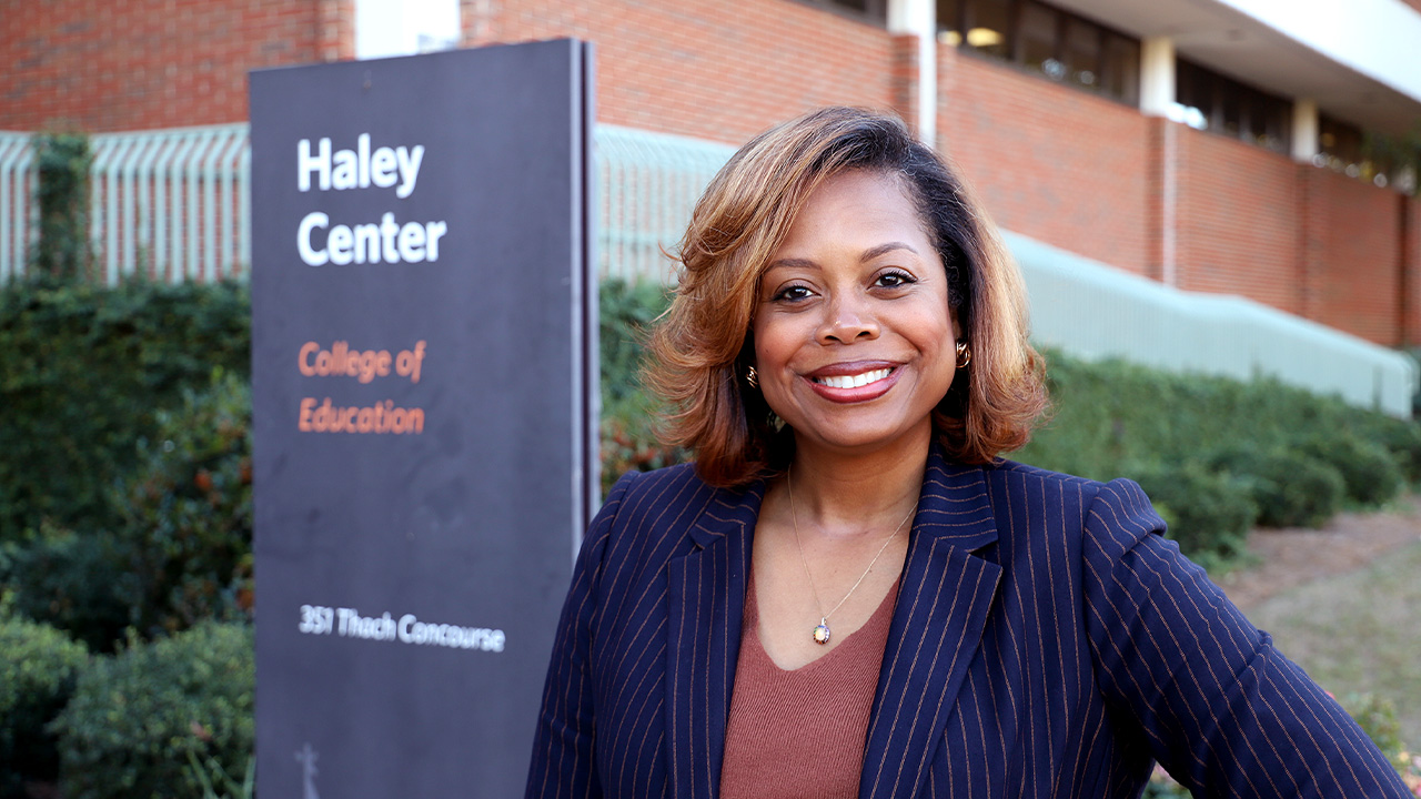 Crystal Smith poses for a photo in front of the College of Education