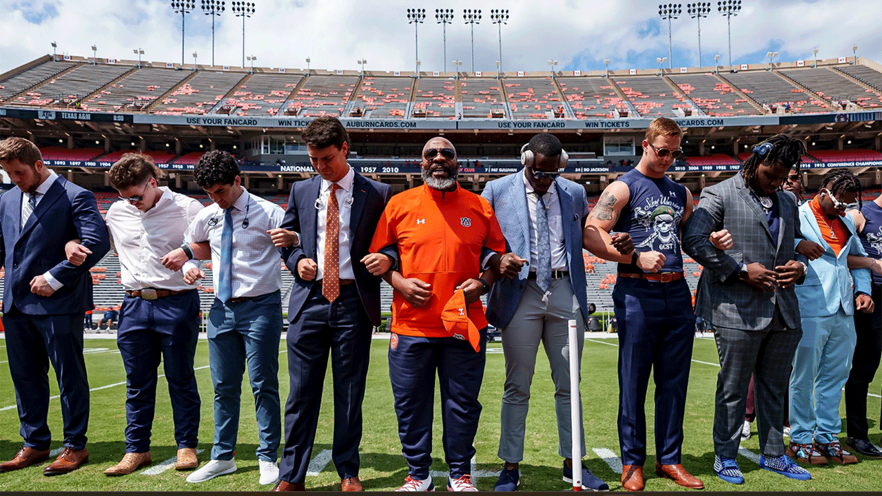 Chette Williams prays with members of the Auburn Football team.