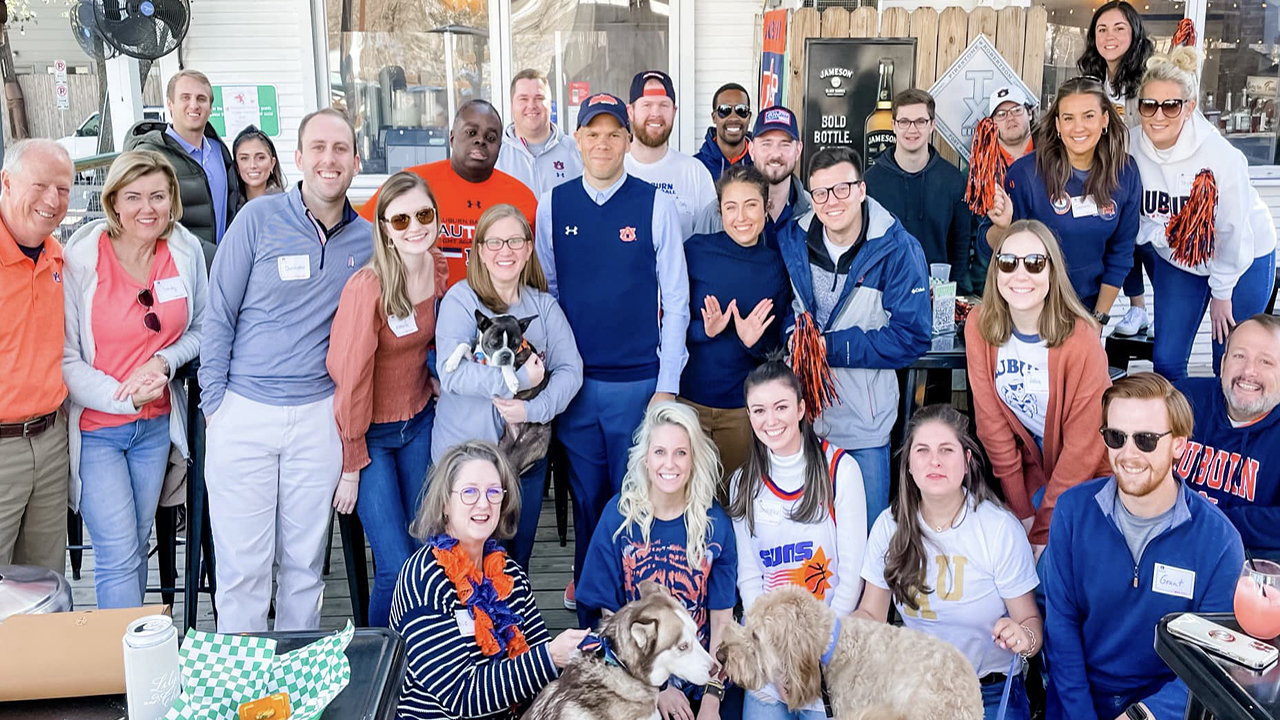 A group of Auburn fans smile for a photo.