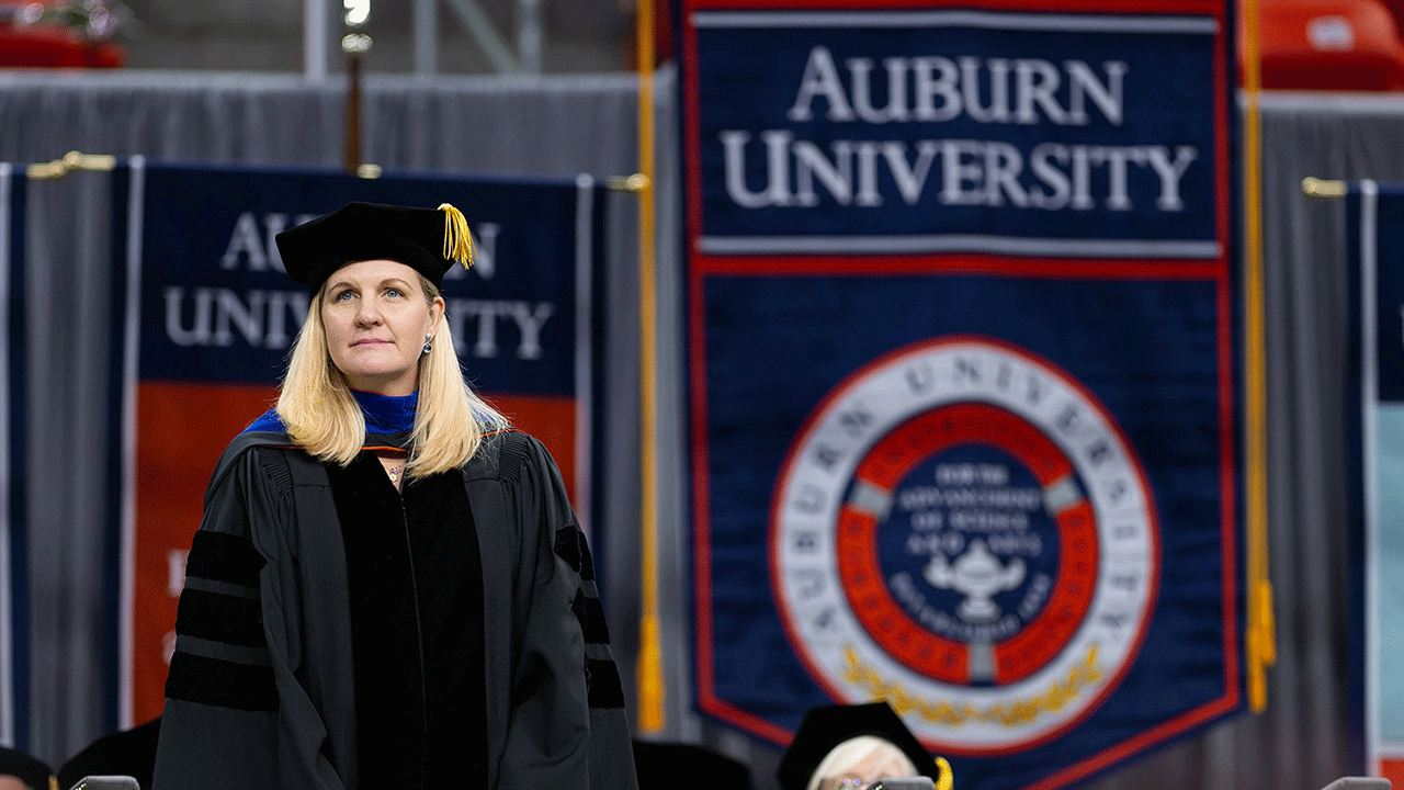Kirsty Coventry stands in front of an Auburn University flag.
