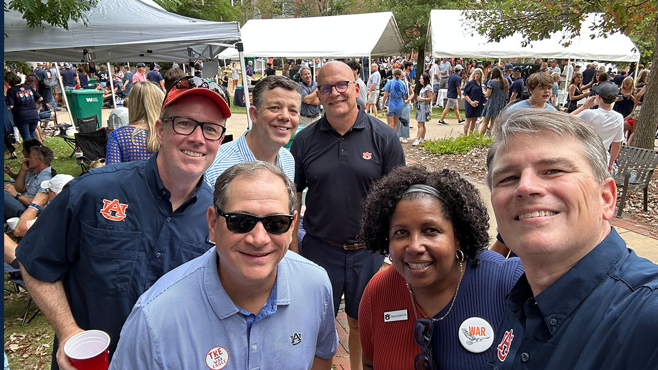 a group of people at at Auburn tailgate. Glenn Mitchell is on the far right. Regenia Sanders is on his right.