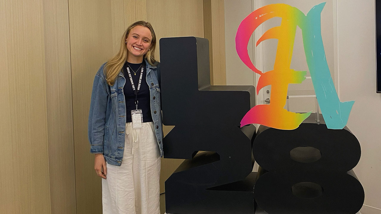 Maddie Marsh standing next to an LA28 sign
