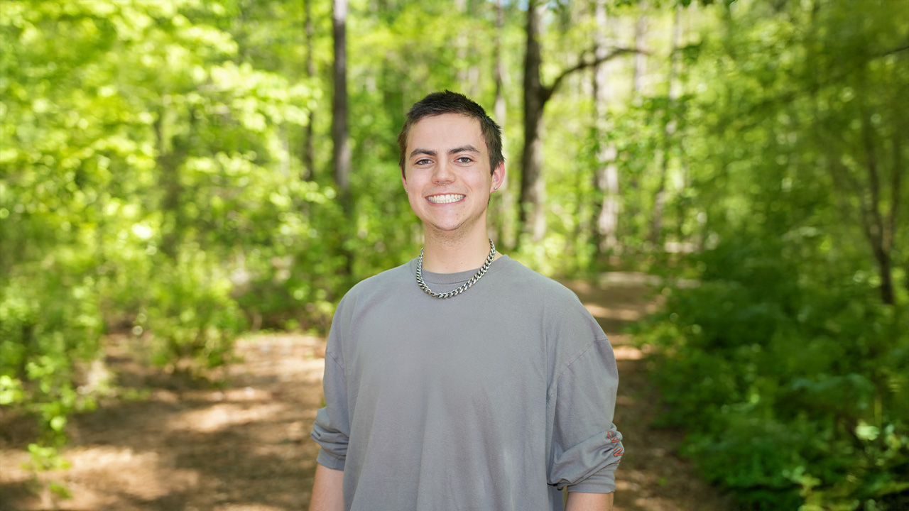 Cooper poses for a photo in the woods