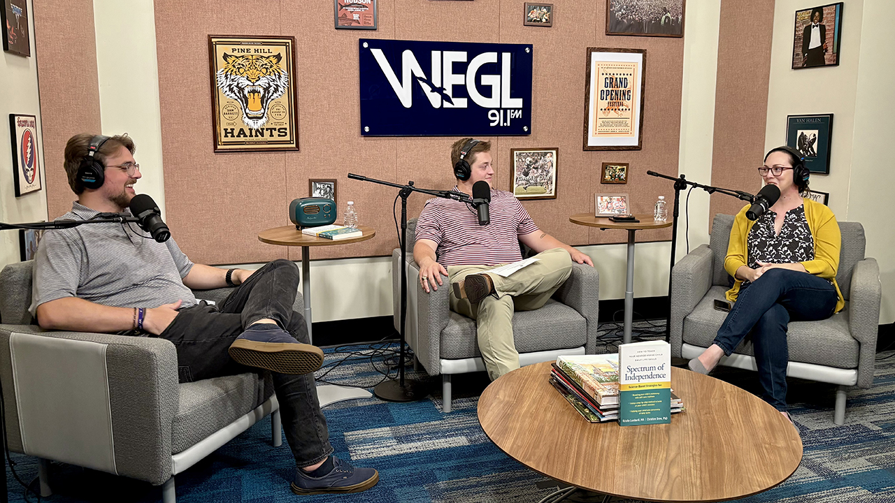 three people on podcast set