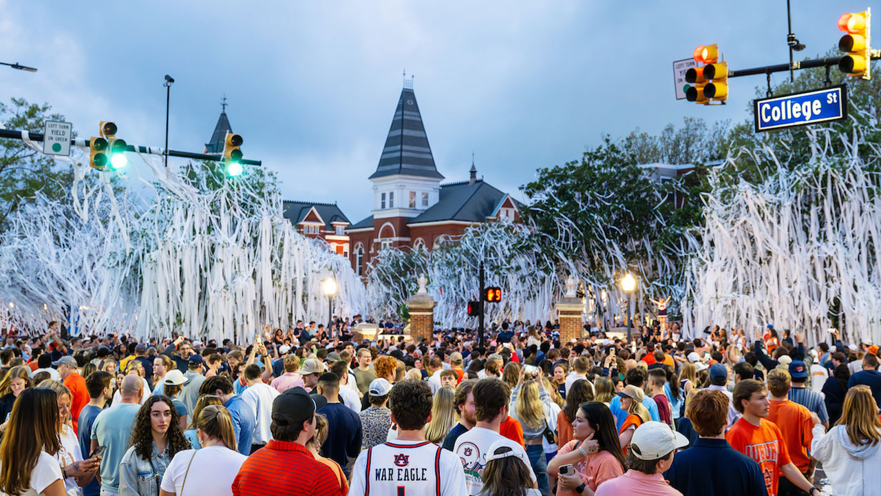 at Toomer's Corner with a crowd of people and trees covered in toilet paper