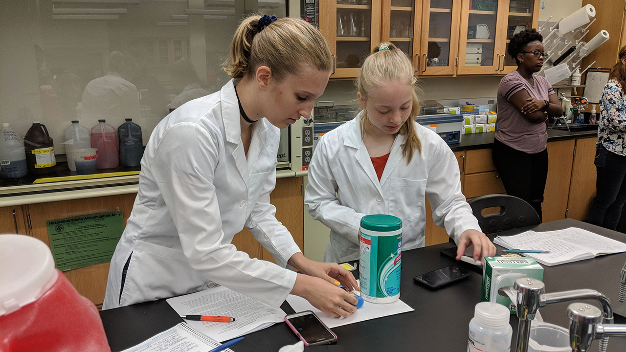 Megan Fitzgerald working in a lab with a student