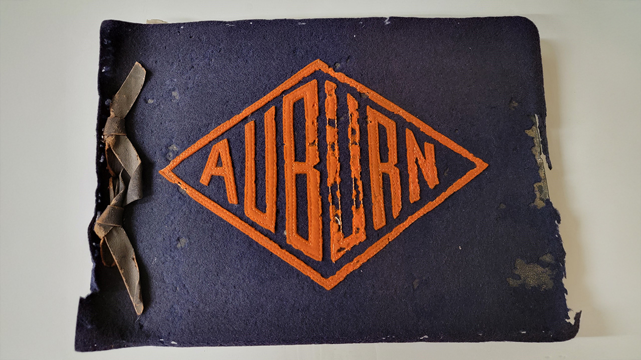The tattered cover of a historic student scrapbook