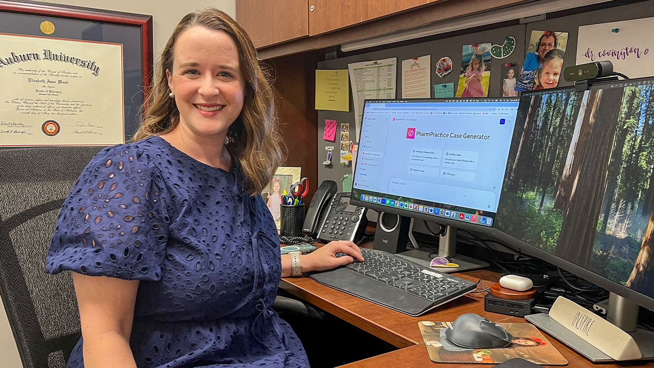 Elizabeth Covington at her office desk. The computer screen shows the custom GPT she created.