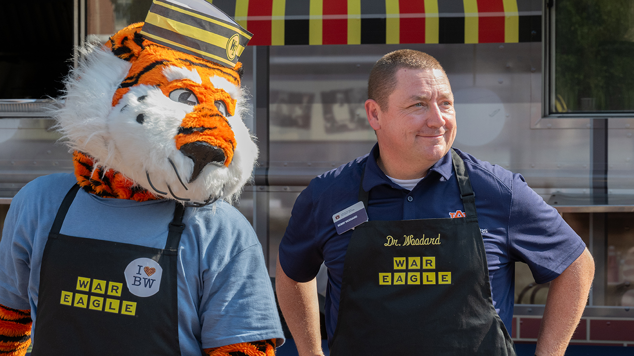 man poses with tiger mascot