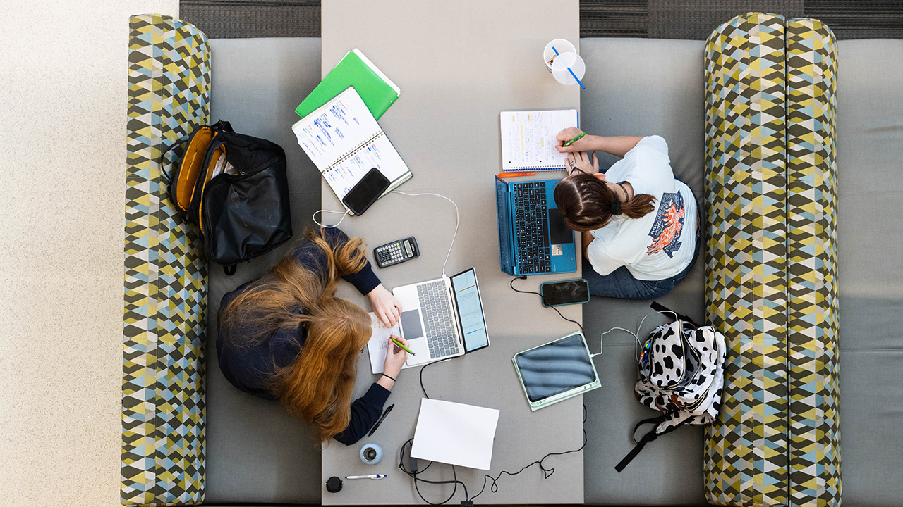 an overhead view of students studying at a table in the library