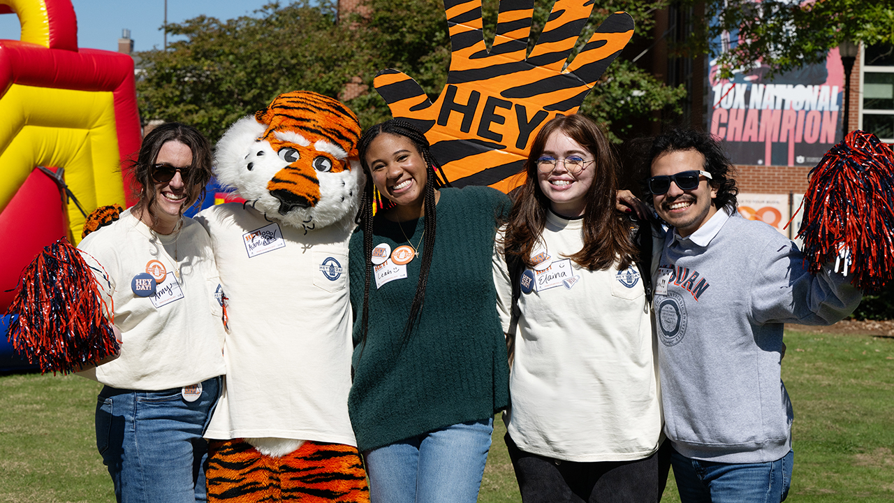 college students and mascot smiling for photos