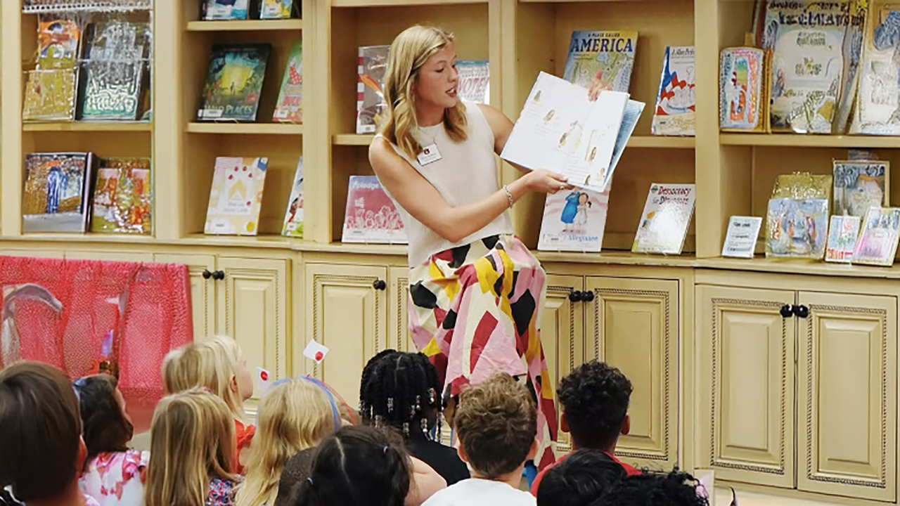 lady reads a book to a class