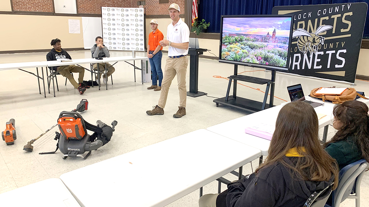 Guest speakers present to a group of Bullock county students in a school auditorium for the AUBCA program