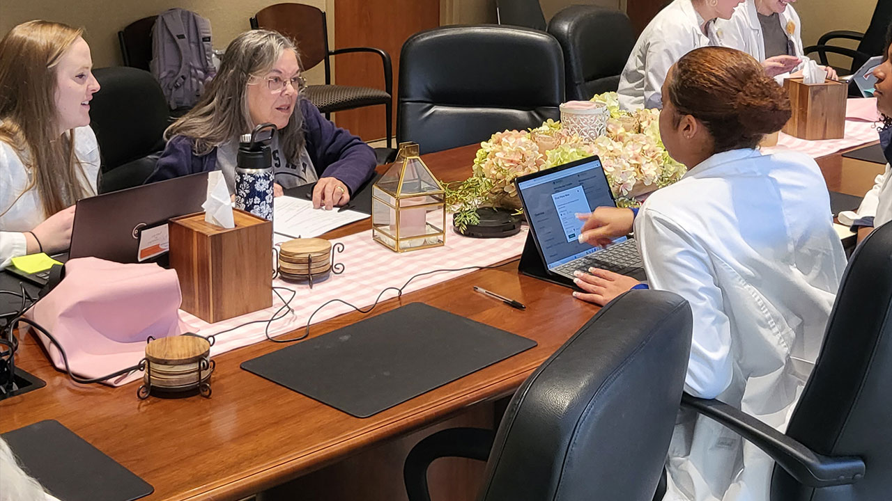 A pharmacy student works with Alabama residents during an AU-SHIP outreach event