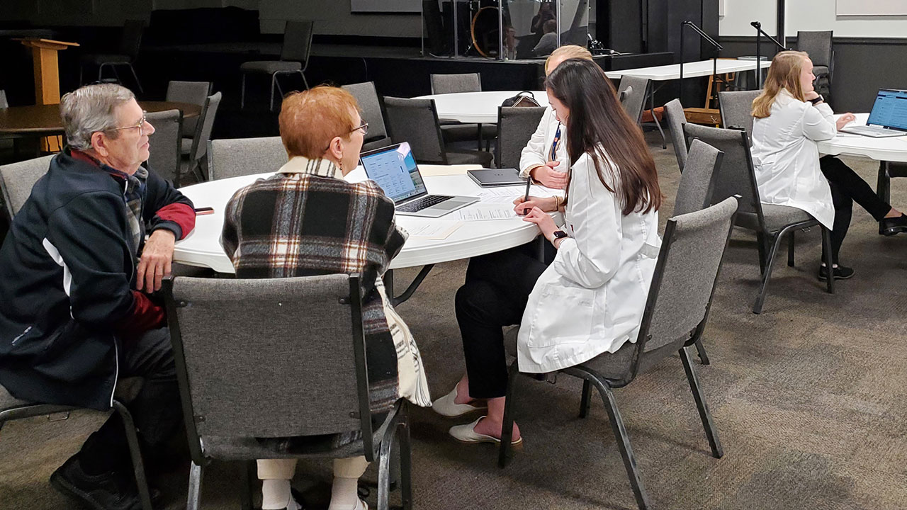 An Auburn pharmacy student helps community members at an AU-SHIP event