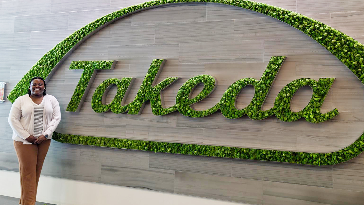 Person stands by Takeda sign