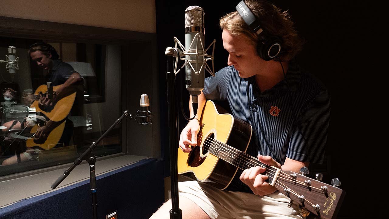 Music student plays guitar in the Lucky Man Studio