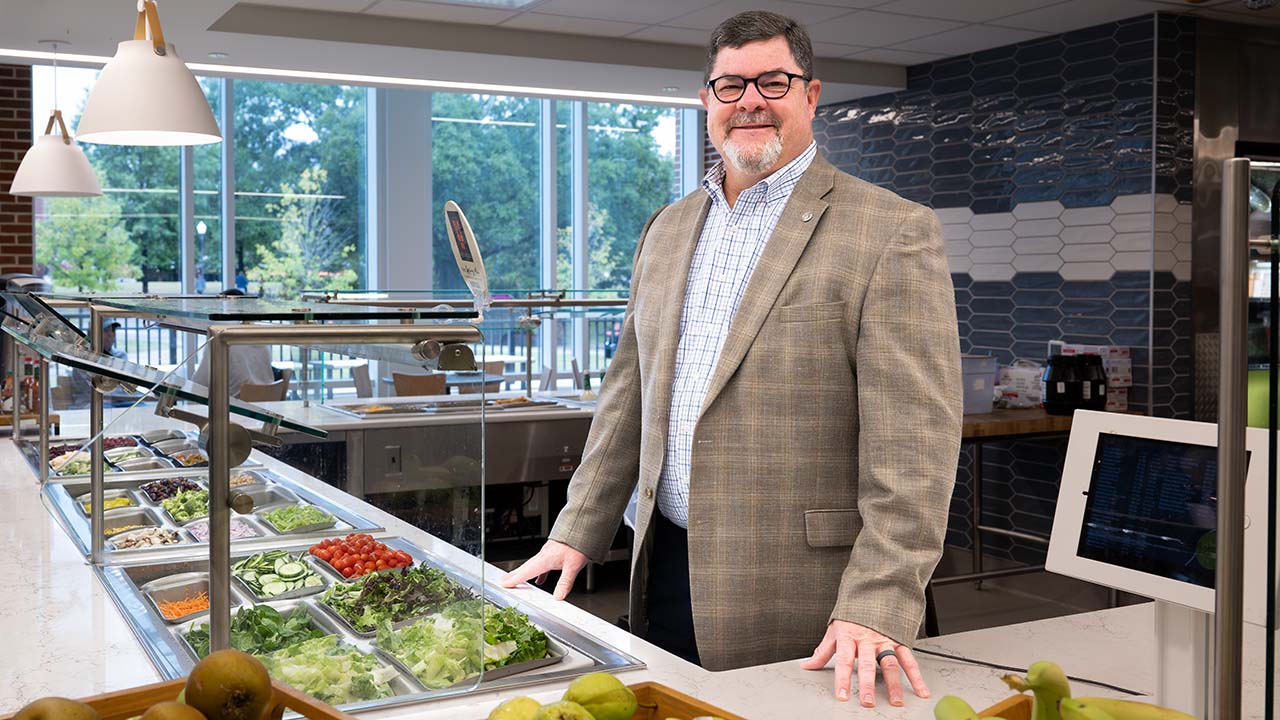 Glenn Loughridge, director of Campus Dining, highlights fresh food options in one of Auburn