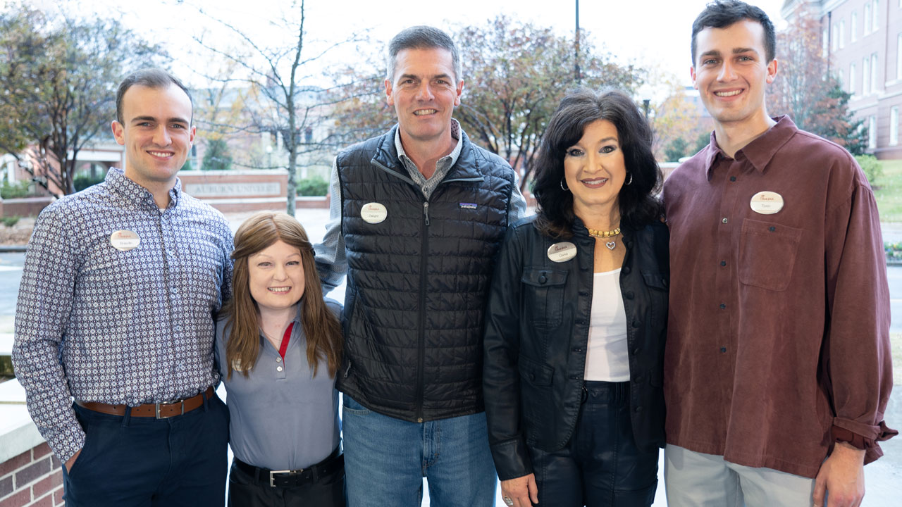 Family of five standing and smiling at the camera.